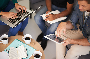 Image showing Utilizing tech to make their meetings more efficient. A team of young business professionals using technology in an informal meeting.