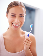 Image showing Taking care of her smile. A young woman brushing her teeth.