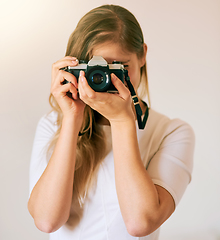 Image showing Freezing this moment in time. Shot of an unrecognizable young woman taking a photo with her camera at home.