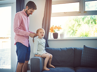 Image showing Not a hair out of place when dad does it. Shot of a father brushing his daughters hair at home.