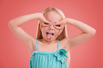 Image showing Playing silly. Studio shot of a young girl posing on an orange background.