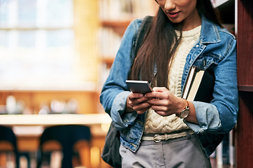 Image showing Meet me in the library. Closeup shot of a university student texting on her cellphone in the library at campus.