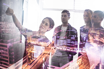 Image showing Re-evaluating plans to reinvent the city. Multiple exposure shot of a group of businesspeople working on plans superimposed over a city.