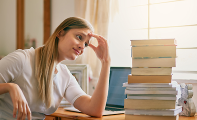 Image showing This is what I get for procrastinating. Shot of a young woman looking overwhelmed by the pile of books on her desk.