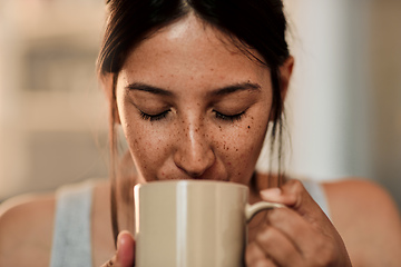 Image showing A good day starts with good coffee. Shot of a young woman enjoying a cup of coffee at home.