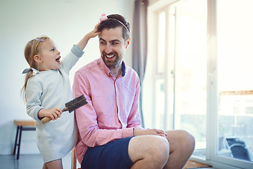 Image showing Future hairstylist in the making. Shot of an adorable little girl brushing her fathers hair at home.