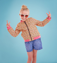 Image showing Showing off my funky moves. Studio shot of a little girl wearing funky glasses on a blue background.