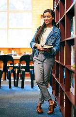 Image showing The library is a place to experience a wealth of knowledge. Portrait of a university student standing in the library at campus.