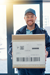 Image showing Delivered on time, every time. Cropped portrait of a handsome delivery man waiting in the lobby with a customers order.