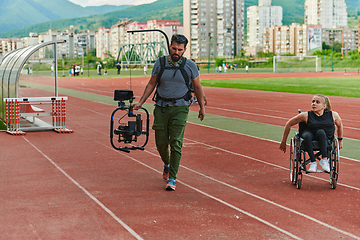 Image showing A cameraman filming the participants of the Paralympic race on the marathon course