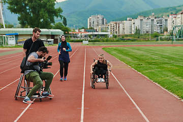 Image showing A cameraman filming the participants of the Paralympic race on the marathon course