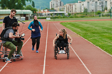 Image showing A cameraman filming the participants of the Paralympic race on the marathon course