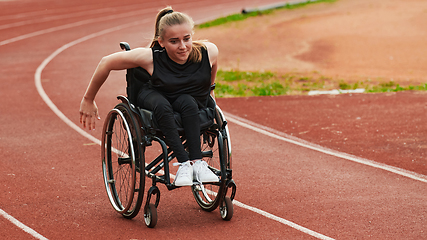 Image showing A woman with disablity driving a wheelchair on a track while preparing for the Paralympic Games