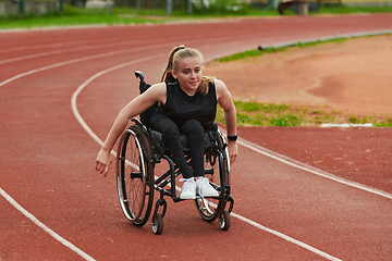 Image showing A woman with disablity driving a wheelchair on a track while preparing for the Paralympic Games