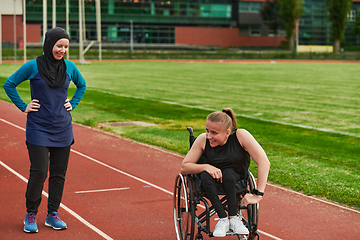 Image showing A Muslim woman in a burqa running together with a woman in a wheelchair on the marathon course, preparing for future competitions.