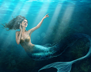 Image showing Siren of the sea. Shot of a mermaid swimming in solitude in the deep blue sea - ALL design on this image is created from scratch by Yuri Arcurs team of professionals for this particular photo shoot.