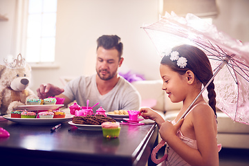 Image showing Every great childhood memory includes a royal tea party. Shot of a father and his little daughter having a tea party together at home.