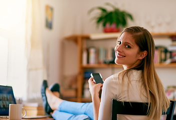 Image showing I cant imagine my life without wifi. Portrait of a young woman using her smartphone while sitting at her desk at home.