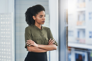 Image showing Never let fear or self-doubt cloud your judgment. Shot of a young businesswoman looking out of a window in her office.