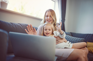 Image showing Wave hello to nana. Shot of an adorable little girl using a laptop with her mother on the sofa at home.