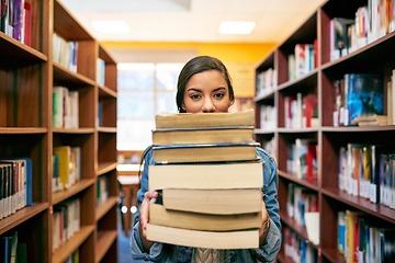 Image showing Its a stack of knowledge. Portrait of a university student holding a pile of books in the library at campus.