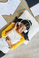 Image showing Selecting the perfect music to study to. High angle shot of a young female student listening to music while studying at home.