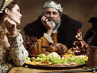 Image showing Royal life can be tedious.... A bored queen sitting alongside her husband at a banquet.