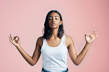 Image showing Namaste. Studio shot of a beautiful young woman meditating against a pink background.