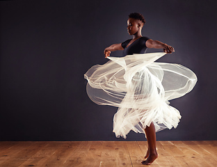 Image showing Freedom of expression. Young female contemporary dancer using a soft white white skirt for dramatic effect.