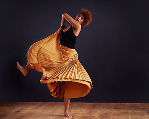 Image showing Earth dance. Female contemporary dancer in a dramatic pose against dark background.