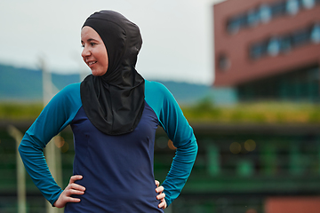 Image showing A Muslim woman with a burqa, an Islamic sportswoman resting after a vigorous training session on the marathon course. A hijab woman is preparing for a marathon competition