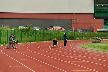 Image showing A cameraman filming the participants of the Paralympic race on the marathon course