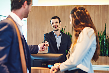 Image showing Time to pay for your stay. Cropped shot of a businessman and businesswoman checking into a hotel.