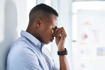 Image showing Let me take a minute to think clearly. Shot of a young and stressed businessman suffering from a headache while trying to work in the office.