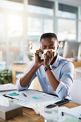 Image showing Hes booking an appointment with the doctor right away. Shot of a sickly young businessman taking a phone call while covering his nose with a tissue in his office.