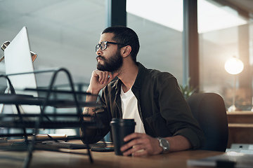 Image showing Focus and consistency keeps you on task. Shot of a young businessman using a computer during a late night in a modern office.