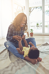 Image showing Bonding with her baby. Full length shot of a young mother and her little baby girl at home.