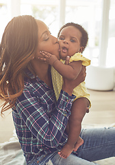 Image showing Showering her with kisses. Cropped shot of a young mother and her little baby girl at home.