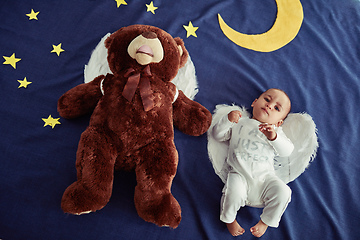 Image showing Babies are angels sent from heaven. Concept shot of an adorable baby boy and a teddy bear wearing angel wings against an imaginary night time background.