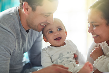 Image showing Born into a home full of love. Shot of an adorable baby boy bonding with his father and father at home.