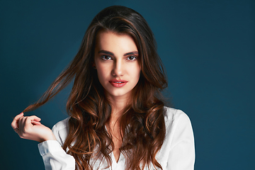 Image showing You gorgeous and dont you forget it. Studio shot of an attractive young fashionable woman posing against a blue background.