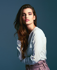 Image showing Its all about the perfect pose. Studio shot of an attractive young fashionable woman posing against a blue background.