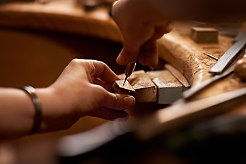 Image showing Working with your hands is the purest art form. A person using a tool to work on a piece of wood.