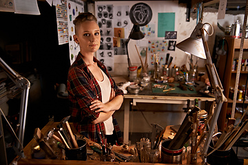 Image showing Organized chaos. Shot of a beautiful young woman sitting in a workshop.