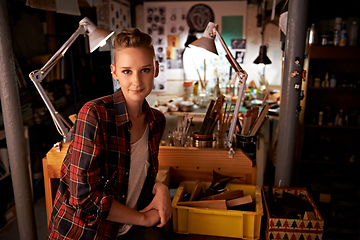 Image showing Shes proud of what she can make. Shot of a beautiful young woman sitting in a workshop.