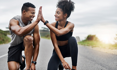 Image showing The game is on. Shot of a sporty young couple high fiving each other while exercising outdoors.