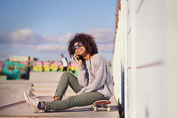 Image showing Why walk when you can skate. Shot of a young woman out skateboarding in the city.