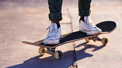 Image showing These sneakers were made for skating. A cropped shot of a woman standing on a skateboard.