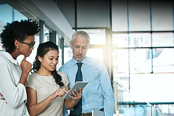 Image showing Using technology to take brainstorming to the next level. Shot of a business team using a digital tablet while having an informal meeting.