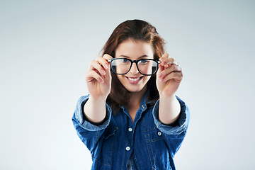 Image showing I see you. Studio portrait of a young woman holding a pair of spectacles against a grey background.